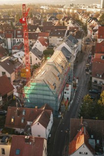 Aerial view of a construction site in a city with an urban environment and roof work, carpentry,