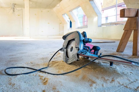 Interior of a construction site with a saw on the ground, carpentry, renovation, roof extension,