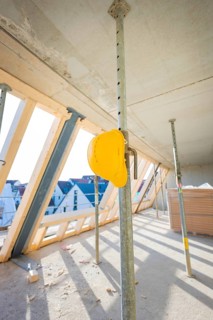 Shell with wooden roof racks and construction site safety equipment indoors, carpentry, renovation,