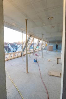 Unfinished interior of a construction site with a view of the residential area, construction site