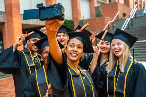 Group of happy diverse university graduates celebrating their achievement, smiling and laughing
