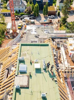 View of the upper construction site with workers and building materials, surrounded by urban