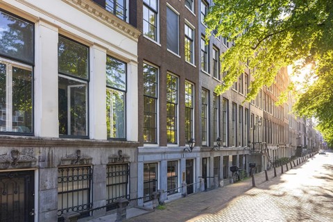 Holland, Amsterdam canals with boats, scenic bridges and historic city center, UNESCO World