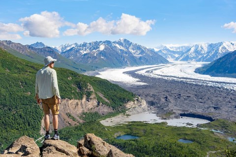 Young man enjoying the view, view of impressive mountain landscape with Matanuska glacier and