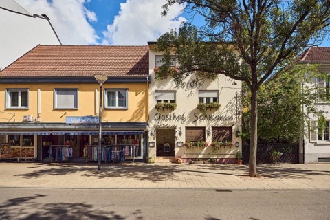 Gasthof Schwanen, Cheema fashion store, commercial building, lantern, city trees, blue sky, cumulus