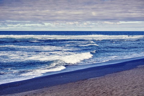 Coastline with wavy sea and sandy beach under cloudy sky, Playa del Janubio, Yaiza Lanzarote