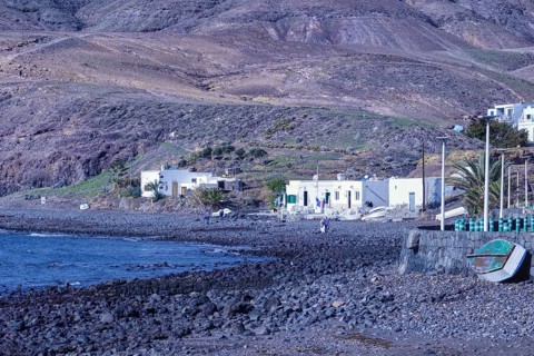 Small houses along a rocky coastline with a deep blue sea, Playa Quemada, Yaiza Lanzarote