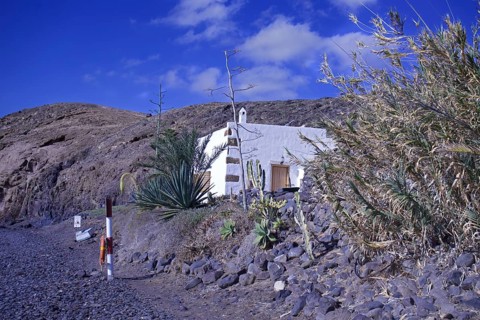 Lonely house in a barren volcanic landscape under a clear blue sky, Playa Quemada, Yaiza Lanzarote