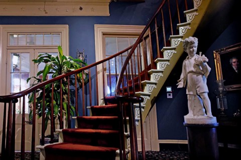 Elegant wooden staircase with sculpture in a historic interior, zero