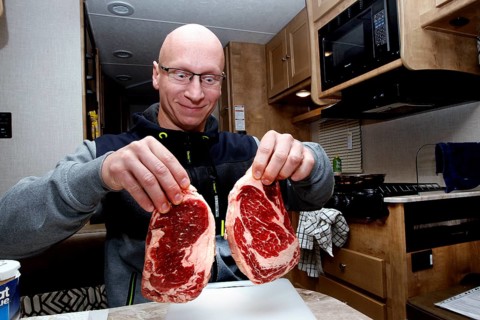 A man in an RV holds two large steaks in Middletown, Middletown, USA
