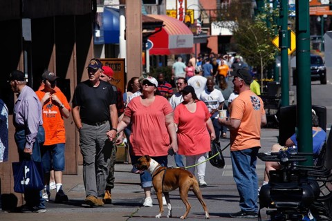 People walk a dog along Gatlinburg's busy main street, Gatlinburg, Tennessee, USA