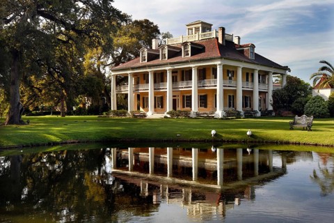 Elegant southern manor house with veranda and reflecting pond in a well-kept garden, zero