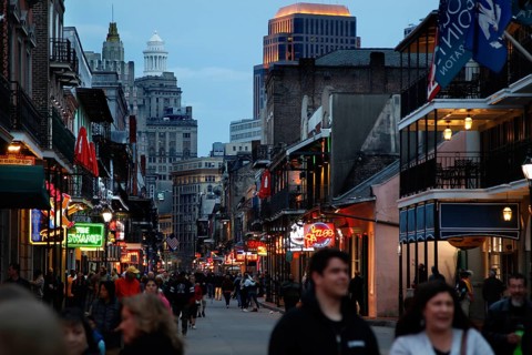 Evening atmosphere on Bourbon Street with illuminated shops and people on the street, New Orleans,