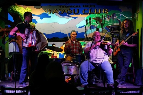 Band playing lively music with accordion and banjo on a colorful stage, New Orleans, Louisiana, USA