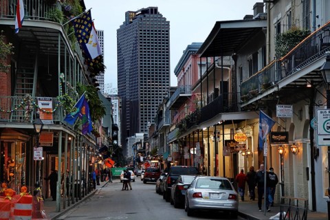 Nocturnal street scene in the French Quarter with illuminated buildings and cars, New Orleans,