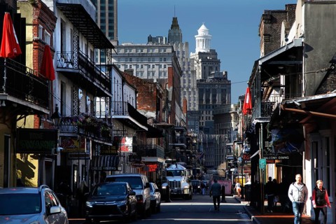 Bustling Bourbon Street in the French Quarter with colonial architecture and pedestrians, New