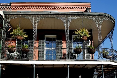 Colonial balcony with decorated ironwork and hanging plants in the French Quarter, New Orleans,