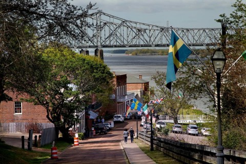 Street view in Natchez with bridge in background and flags along the road, Natchez, Mississippi,