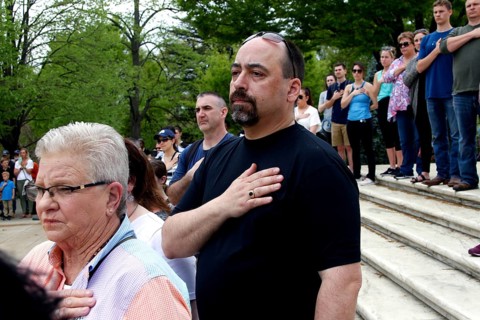 Crowds of people on stairs with hands on their hearts, expression of respect and patriotism,