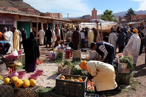 People buy and sell vegetables at a market in Msemrir, Msemrir, Morocco