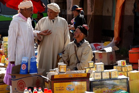 Market scene with men talking in front of a variety of products, Msemrir, Region, MA
