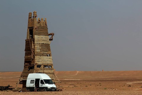 Desert scene with a tall rustic tower and a van in the foreground, Ouarzazate, Morocco