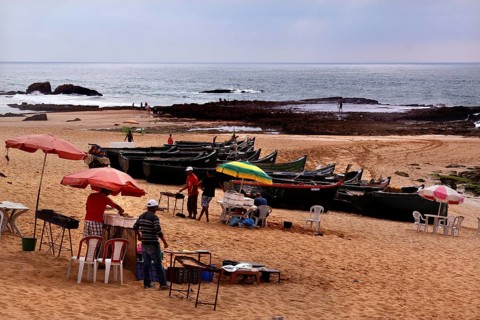 Fishing boats and food stalls in cloudy weather on Oulidia beach, Oulidia, Doukkala-Abda, Morocco