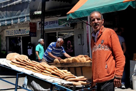 A bread seller presents his goods on the lively Place Mohammed VI in Moulay Idris, Moulay Idris,