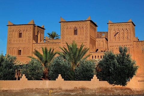 Kasbah Amerhidil with palm trees in the foreground and clear sky in Skoura, Skoura, Drâa-Tafilalet