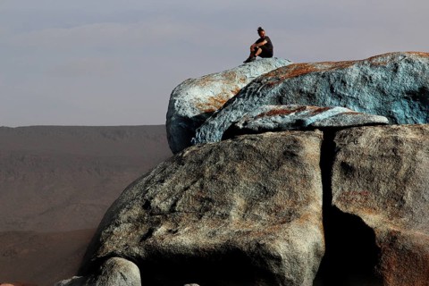 Person on the blue stones of artist Jean Verame with a wide view in Tafraoute, Tafraoute,