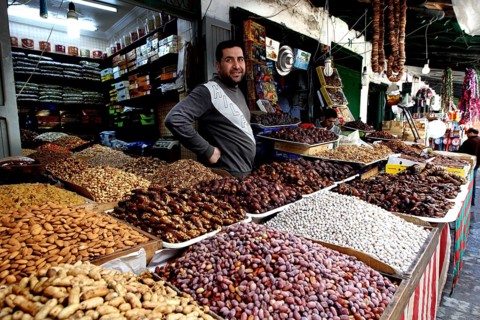 A vendor at a market stand offers a wide range of dates and dried fruits, Tetouan, Medina, Morocco