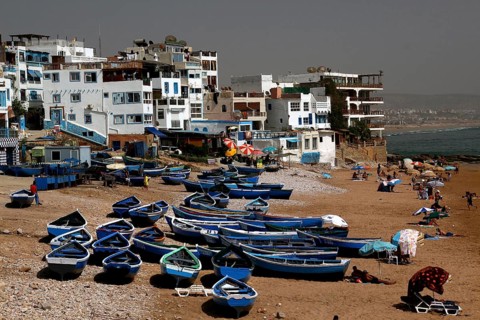 Fishing boats on Taghazout beach surrounded by buildings, Taghazout, Souss-Massa, Morocco