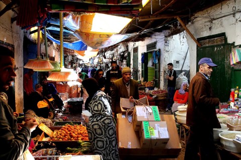 Bustling vegetable market with sellers and customers in a busy market alley, Tetouan, Medina,