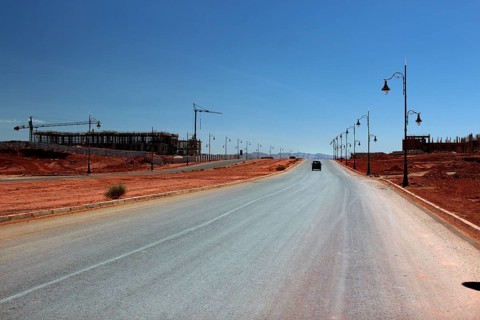 Lonely road with lanterns in dry desert environment under clear sky, Tinerhir, Morocco