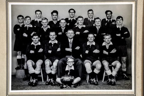Historical black and white portrait of a rugby team in traditional clothing, Whangamomona, New