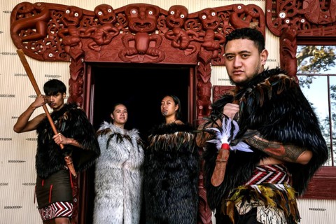 Group of Maori in traditional clothing in front of ornate entrance, Waitangi, New Zealand