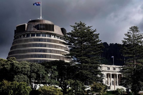 The parliament building 'Beehive' in Wellington surrounded by trees under a cloudy sky, Wellington,