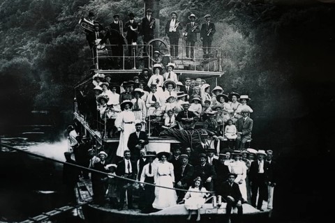 Historical photo of people on a boat on the Whanganui River, Whanganui River, Manawatu-Wanganui,