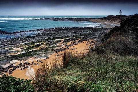 Coastal landscape at Waipapa Point with lighthouse and wave-swept beach, Waipapa Point, Southland,