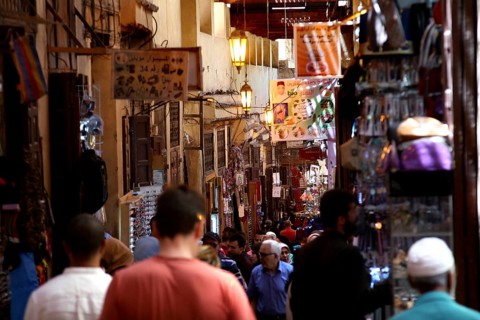 Lively market activity in a narrow, colorful alley with many visitors, Fez, Fez el Bali, Morocco