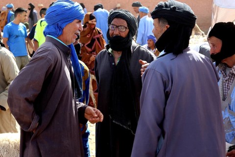 Three men in traditional clothing talking at a cattle market, Guelmim, Guelmim-Oued Noun, Morocco