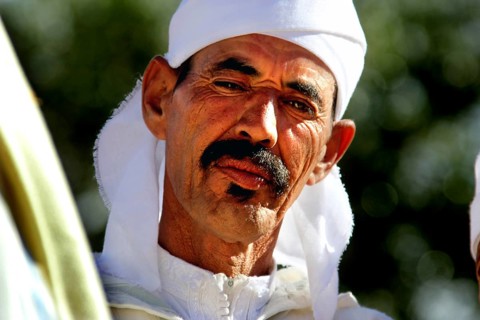Man in traditional dress at the Rose Festival in El Kelâa m'Gouna, serious expression, El Kelâa