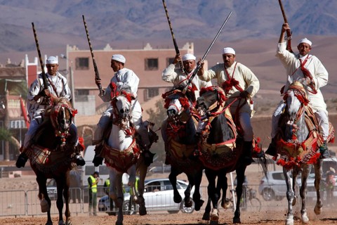 Riders riding decorated horses in an impressive formation at Fantasia, El Kelâa m'Gouna, Morocco