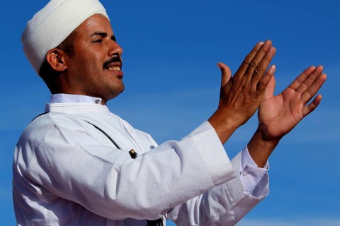 Man in traditional dress claps rhythmically at Berber Festival, Ma El Kelâa M'gouna, Fête des