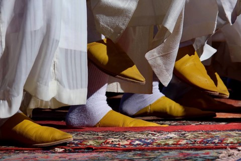 Close-up of traditional yellow Berber footwear on an ornate carpet, El Kelâa m'Gouna