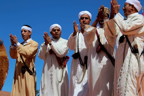Group of men clapping to the beat, dressed in traditional Berber garments, El Kelâa m'Gouna