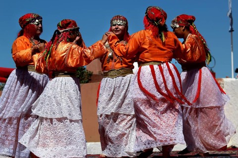 Women in traditional Berber garments dance during a festival, El Kelâa m'Gouna