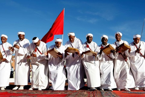 Men in white robes play drums and perform traditional Berber dance, El Kelâa m'Gouna