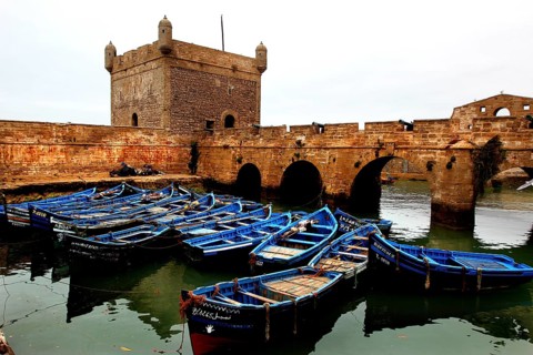 Blue-painted boats in front of the historic fortress and western bastion, Essaouira, Marrakesh-Safi