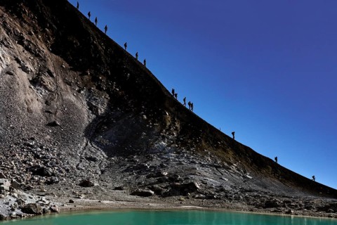 Descent along a steep crater trail at Mount Ngauruhoe under clear skies, Tongariro National Park,